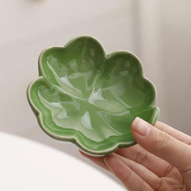 Hand holding the celadon leaf dish to show its size