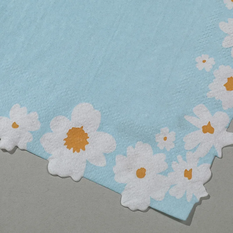 Close-up of the die-cut daisy edge on a sky blue napkin
