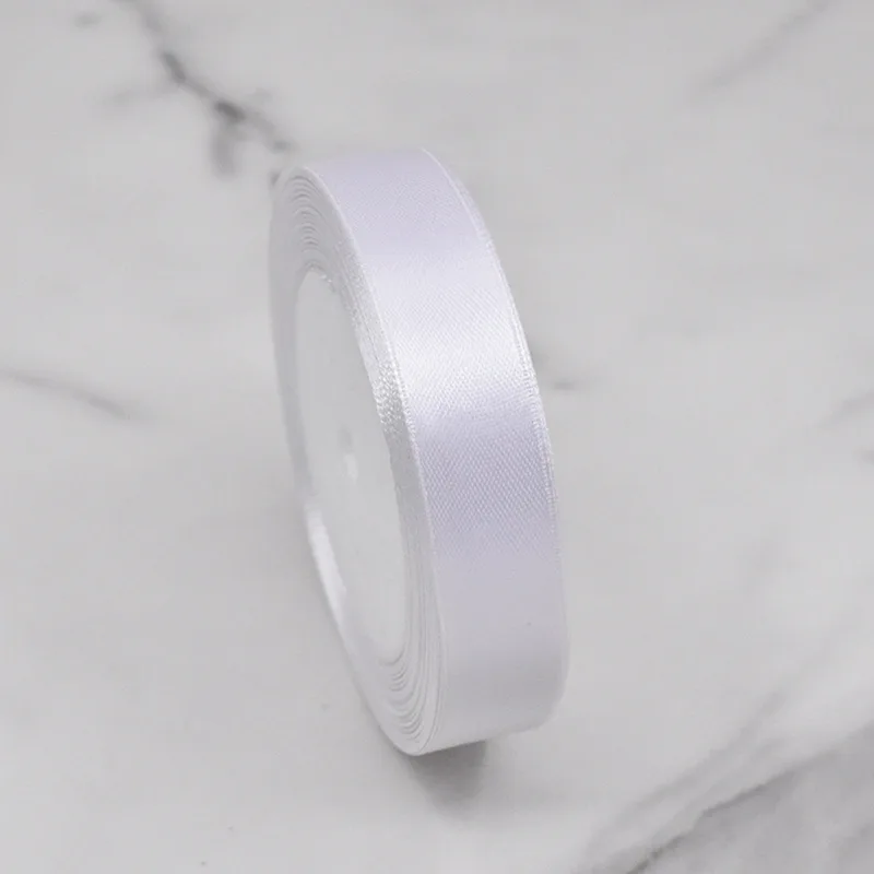 Roll of white satin ribbon on marble