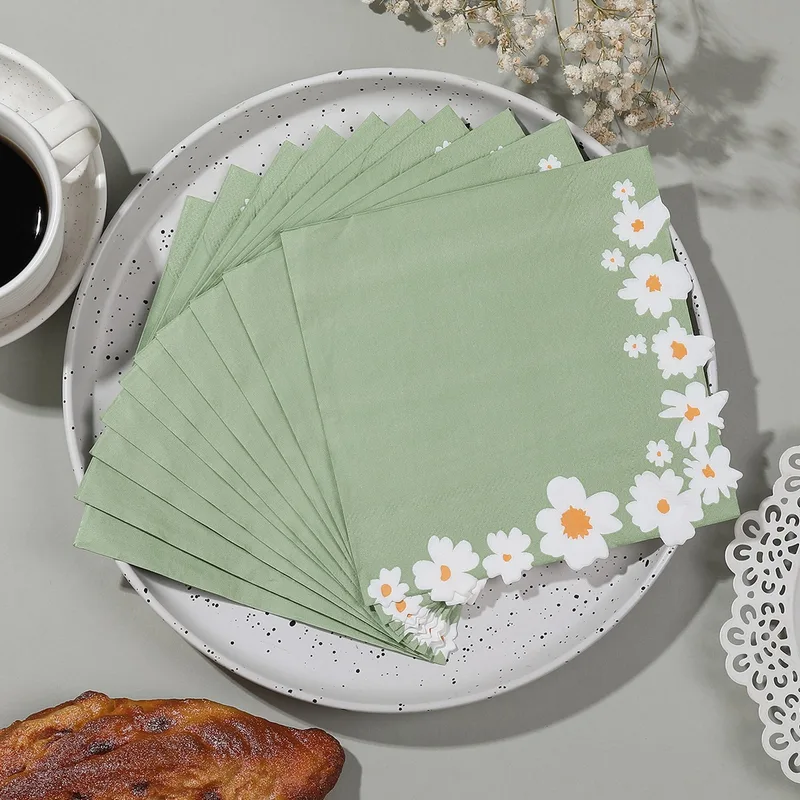 Sage daisy border napkins fanned on a plate
