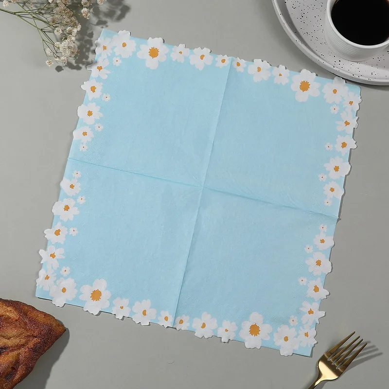 Sky blue daisy border napkin opened on a gray table