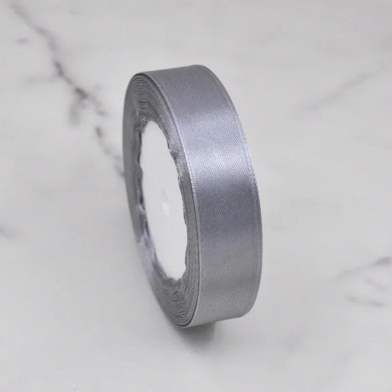 Roll of gray satin ribbon on marble