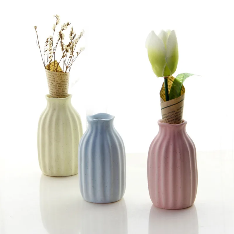 Yellow, blue and pink ribbed bud vases with flowers